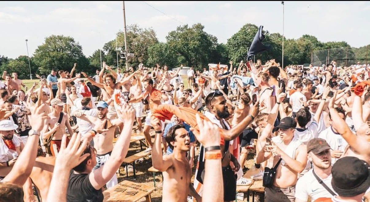 England fans celebrating outdoors at FanZone UK on matchday
